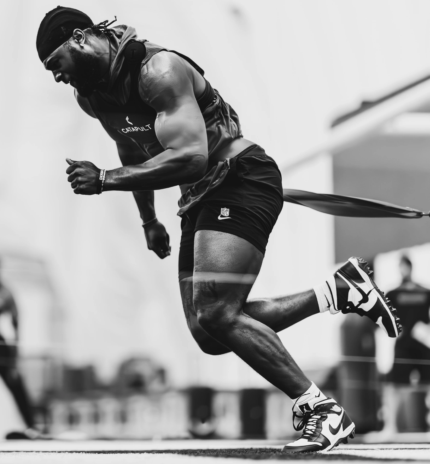 NFL athlete sprinting with resistance band during intense training session