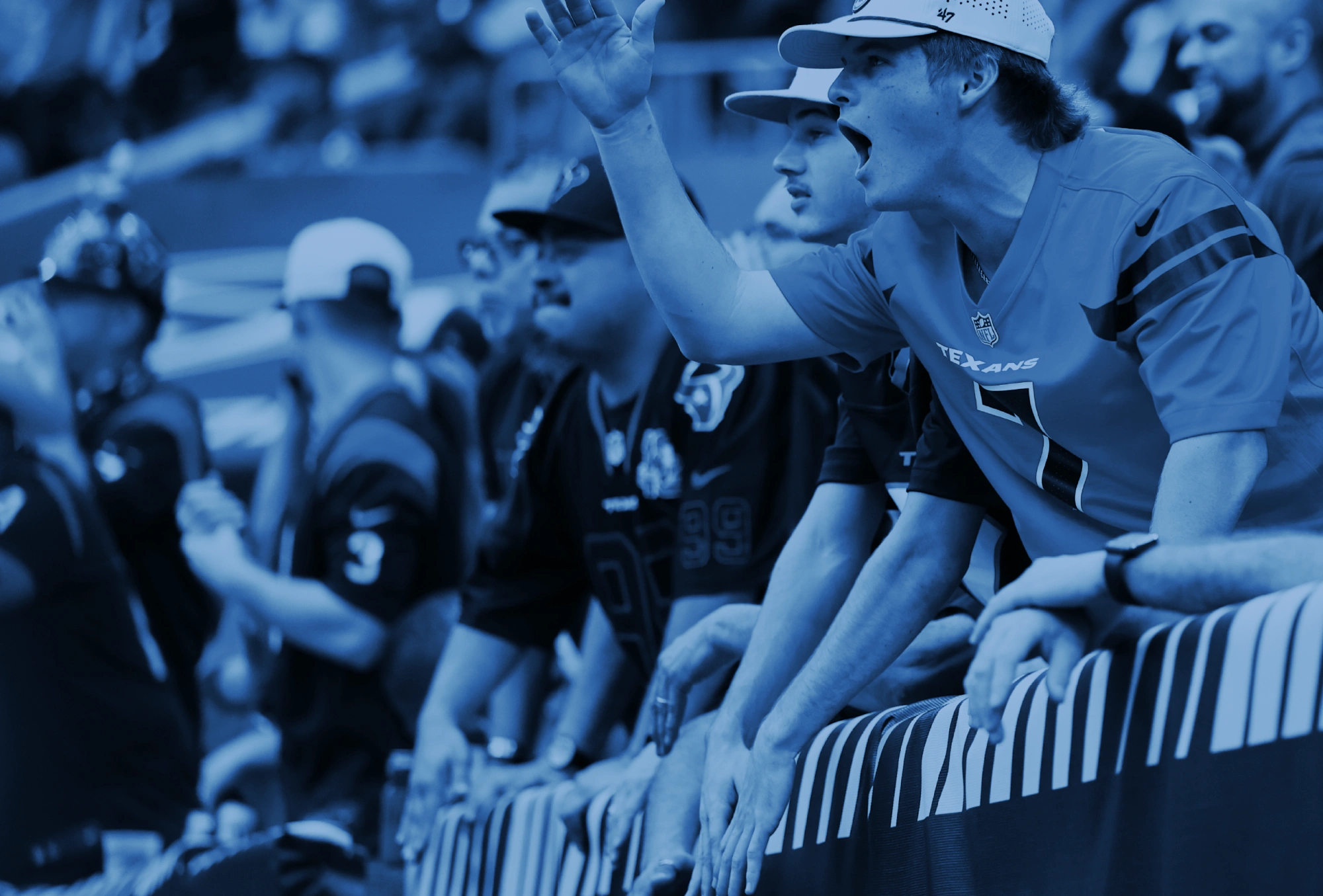 Excited NFL crowd member leaning over railing yelling during Texans matchup